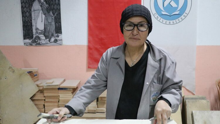 Hat sanatı hocası, tarihi Rum Yetimhanesi'nin bahçesinde taşa şekil veriyor