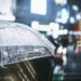 Businessman with umbrella in rainy city