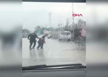 Yunus polisleri, yağmur altında trafiği durdurup engelli vatandaşın yoldan geçmesini sağladı
