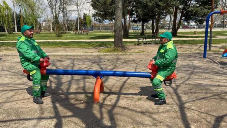 Bursa’da çocuk oyun parkını temizledikten sonra mola veren temizlik görevlileri Enes Akbulut ve Gülamir Taş, parkta çocuklarına dönerek eğlendi. Fotoğraf: Bursa, (DHA)