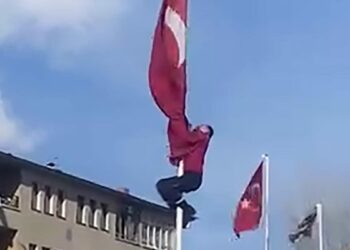 Rüzgârda dolanan bayrağı düzeltmek için 15 metrelik direğe tırmandı; o anlar görüntülendi
