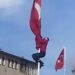 Rüzgârda dolanan bayrağı düzeltmek için 15 metrelik direğe tırmandı; o anlar görüntülendi