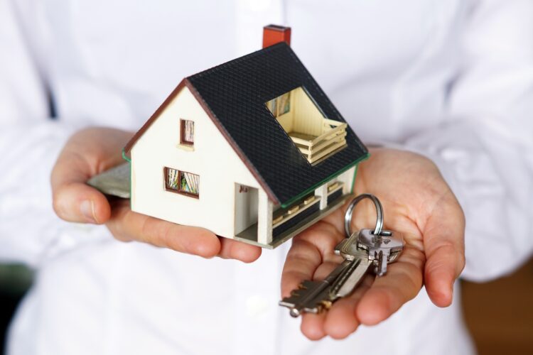 A closeup shot of a person thinking of buying or selling a house