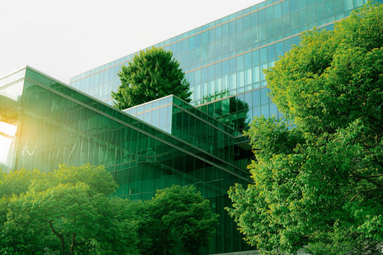 Sustainble green building. Eco-friendly building. Sustainable glass office building with tree for reducing carbon dioxide. Office with green environment. Corporate building reduce CO2. Safety glass.