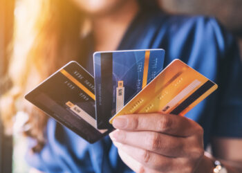 Closeup image of a woman holding and showing credit card