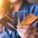 Closeup image of a woman holding and showing credit card