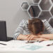 Job occupation and overwork. Close up of tired young good-looking engineer girl with dark hair in striped clothes lying on hands in office, suffering from headache after long work day