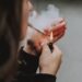 A selective closeup shot of a female lighting up a cigarette with a lighter