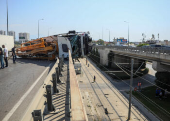 Yan yatan beton pompası kamyonu, üst geçitte asılı kaldı