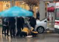 Otomobilin çarptığı yaralıyı yağmurdan korumak için şemsiye tuttular