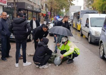 Kadın polis, yaralı ıslanmasın diye başında şemsiyeyle bekledi