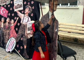Yağmurda Atatürk maketini şemsiyeyle korudu